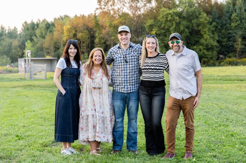 Chris Carey standing with four friends in a grassy field